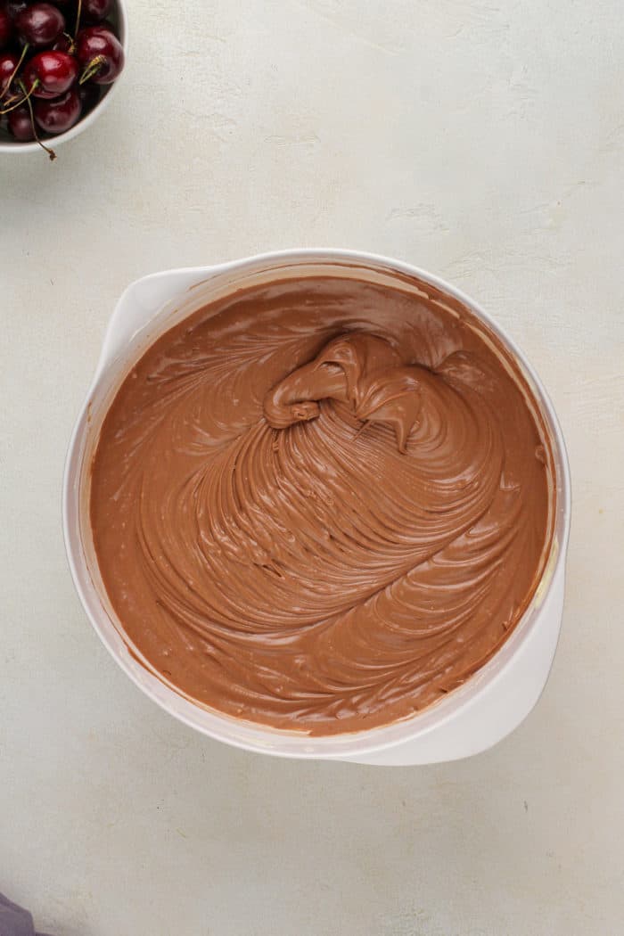 Chocolate cheesecake filling in a white bowl.