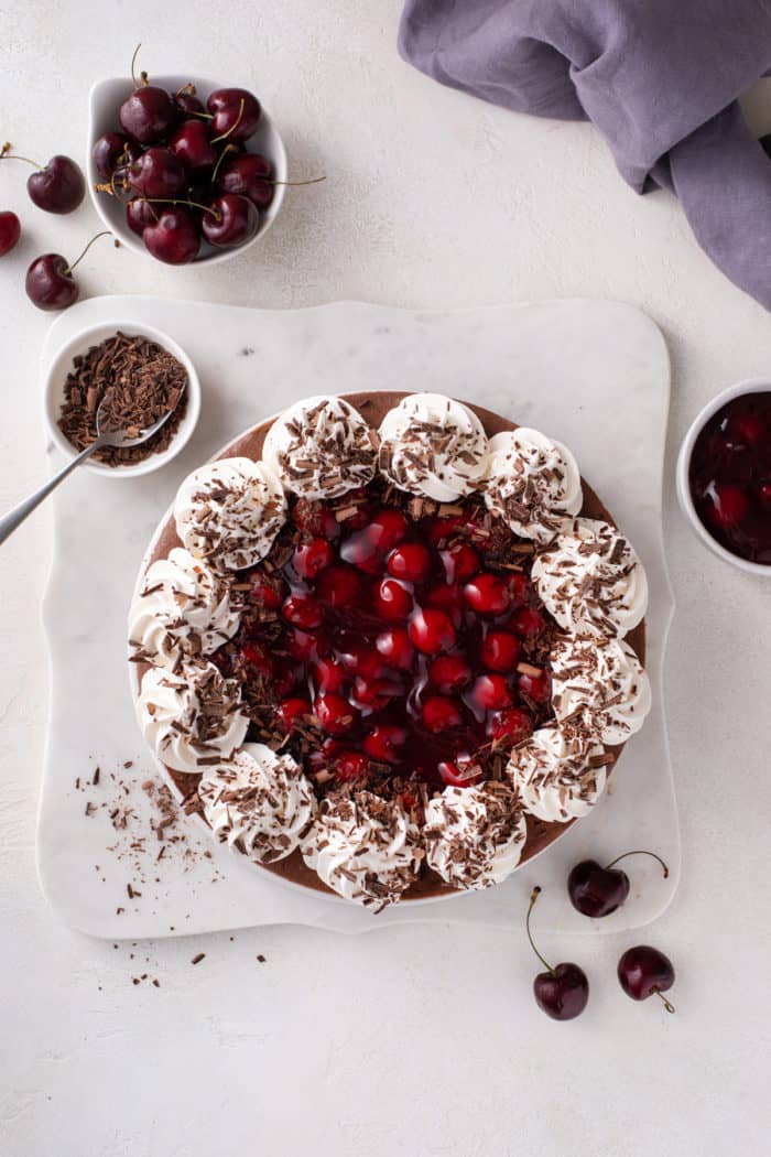 Overhead view of black forest cheesecake on a marble platter.