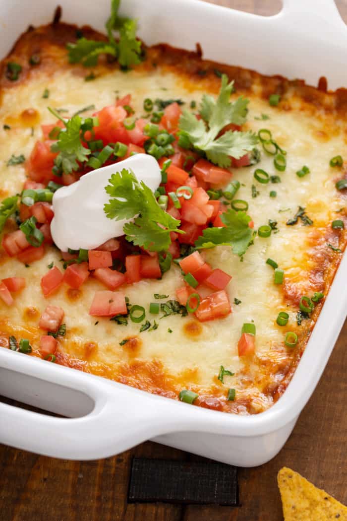 White baking dish filled with baked chili cheese dip.
