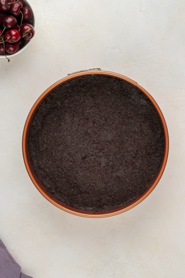 Oreo cheesecake crust in a springform pan.
