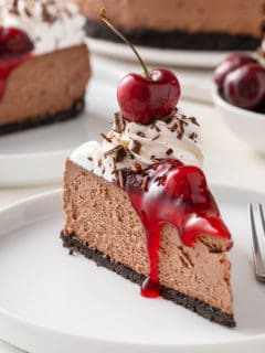 Slice of black forest cheesecake on a white plate.