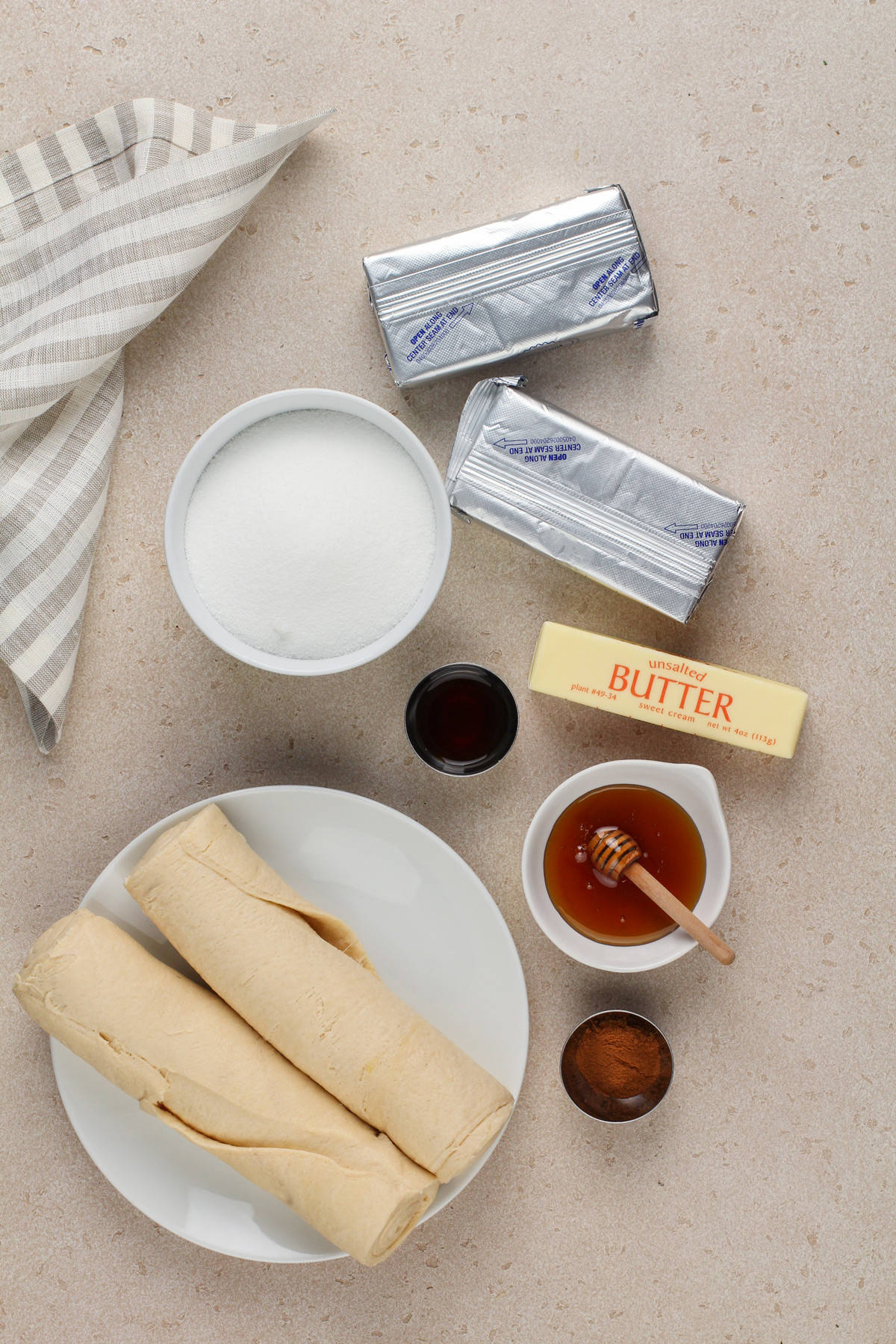 Ingredients for sopapilla cheesecake arranged on a beige countertop.