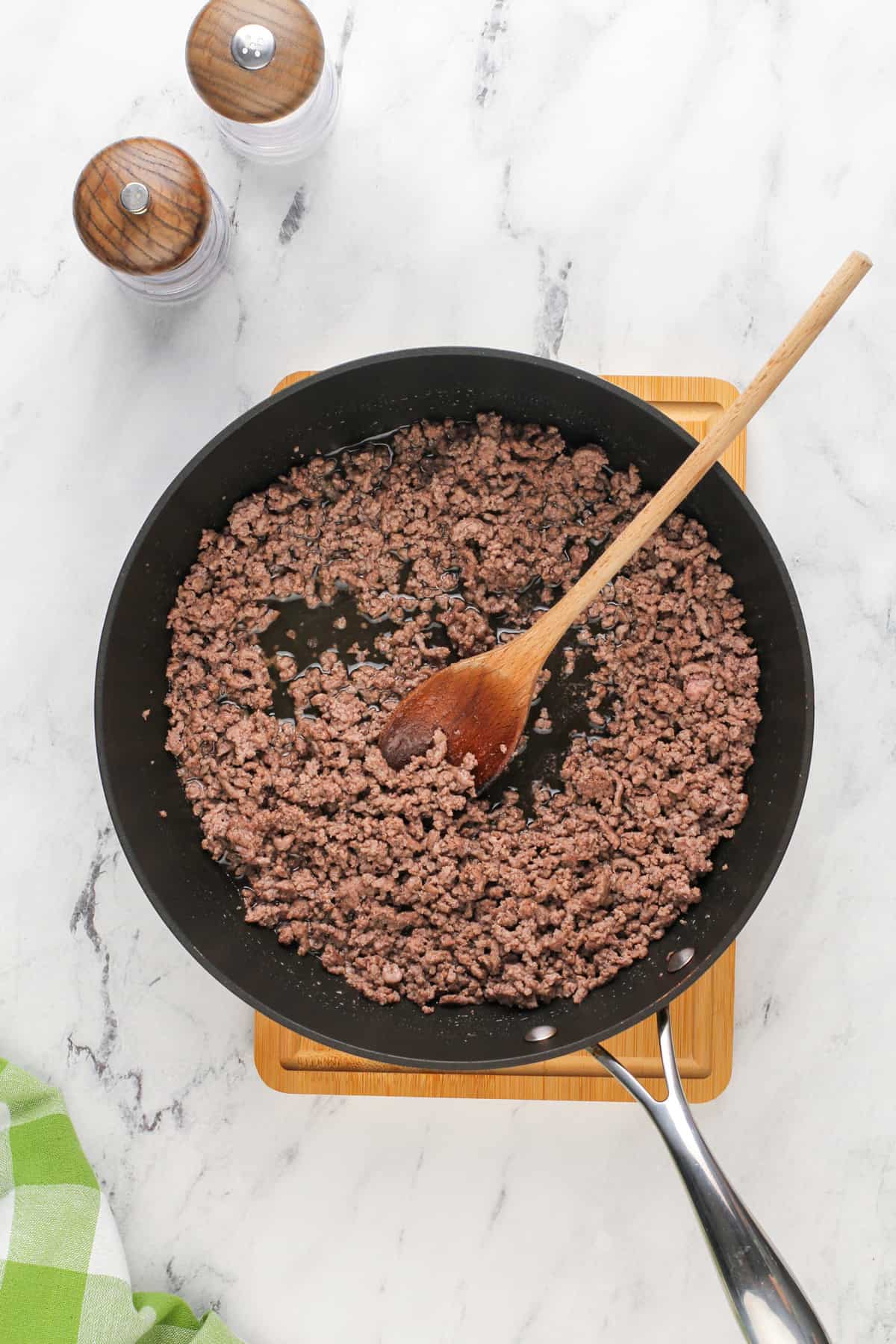 Browned ground beef in a black skillet.