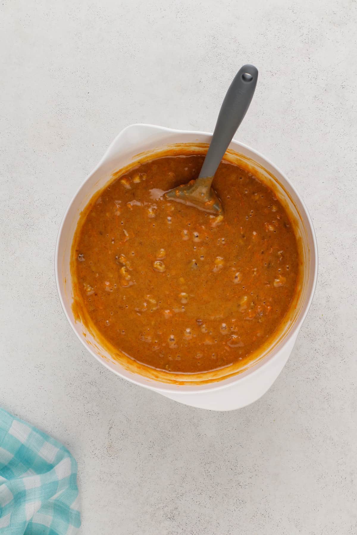 Batter for carrot bundt cake in a white mixing bowl.