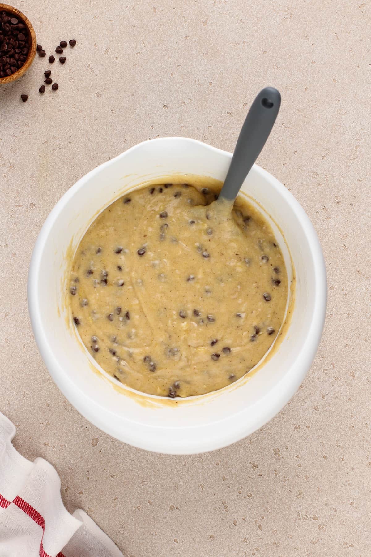 Chocolate chip banana bread batter in a white bowl.