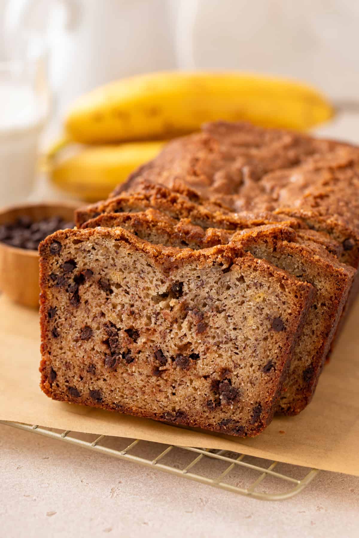 Slices of chocolate chip banana bread leaning against the loaf of bread.