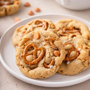 Four salted caramel pretzel cookies arranged on a white plate.