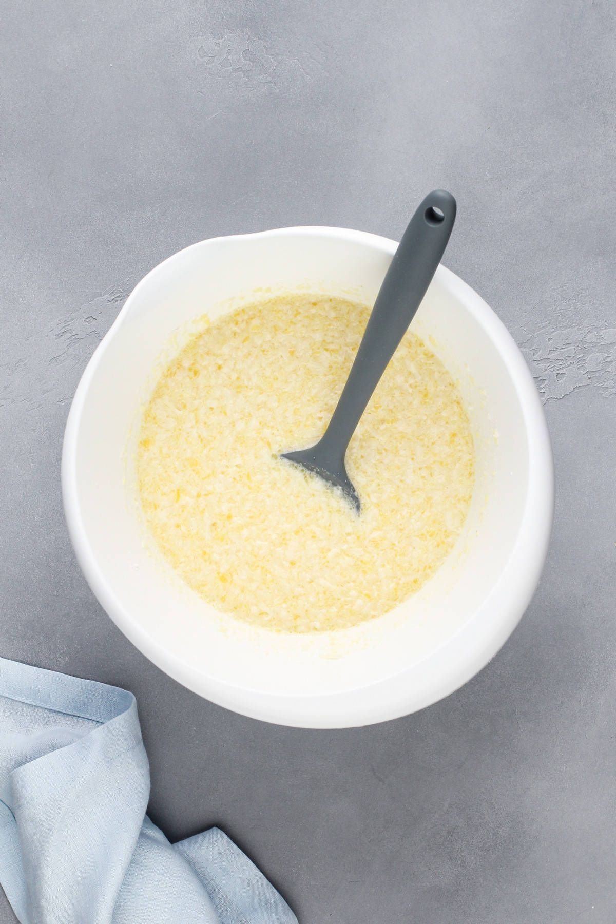 Impossible coconut pie batter stirred together in a white bowl.