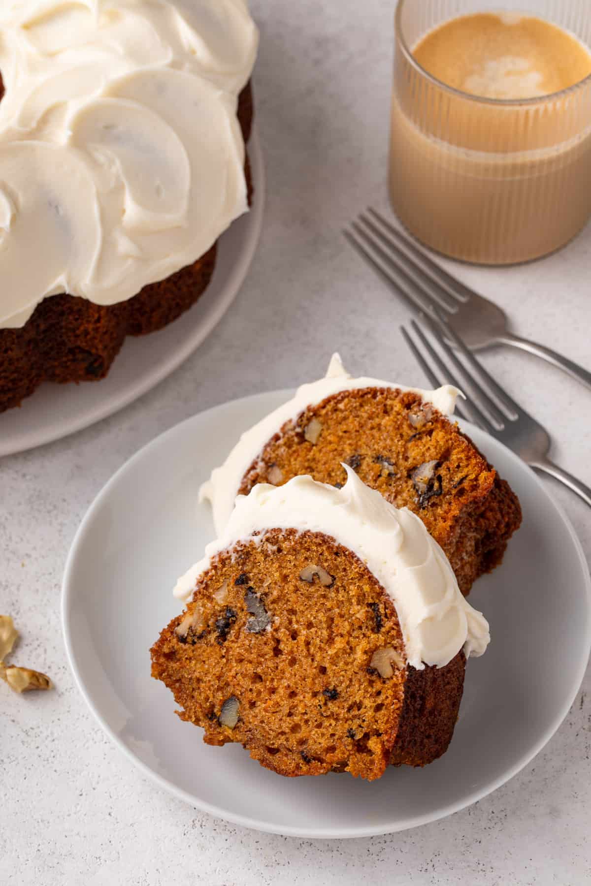 Two slices of frosted carrot bundt cake arranged on a plate.