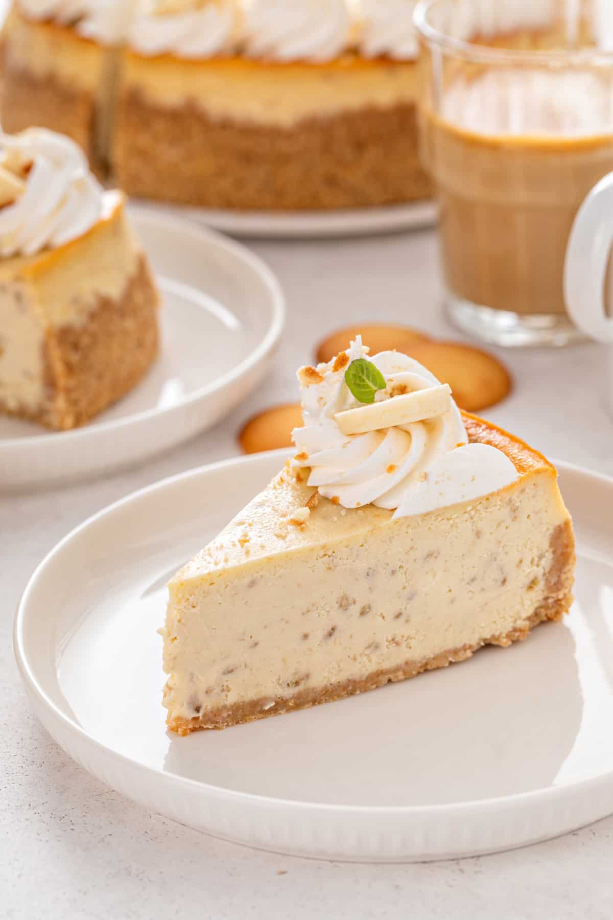 Side view of a slice of banana pudding cheesecake on a white plate.