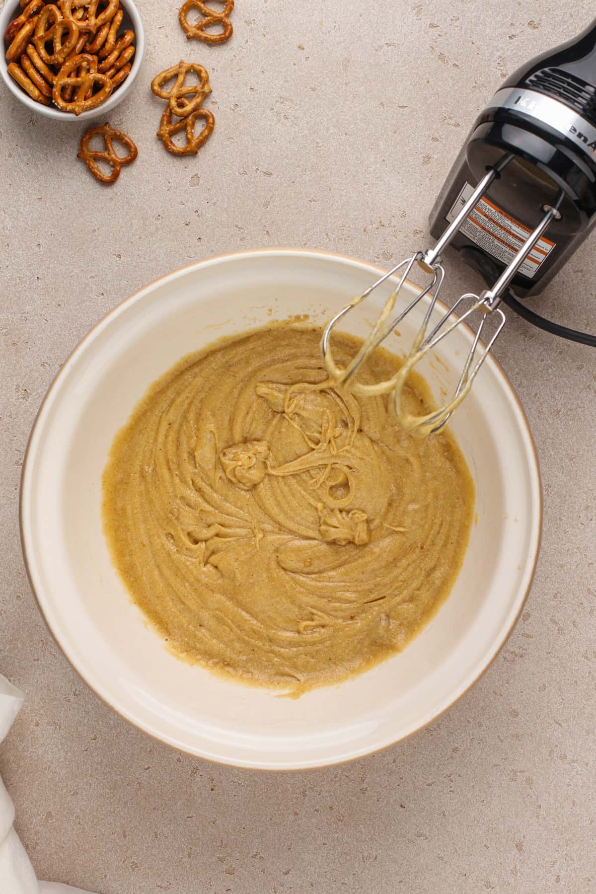 Wet ingredients for salted caramel pretzel cookies mixed in a ceramic mixing bowl.