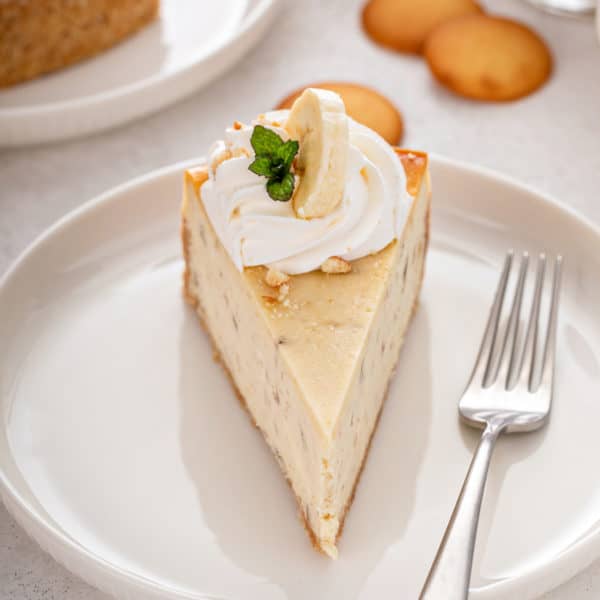 Slice of banana pudding cheesecake on a white plate.