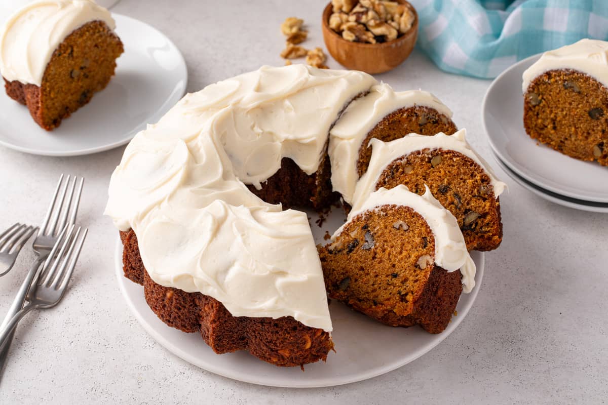 Sliced carrot bundt cake on a white cake plate.