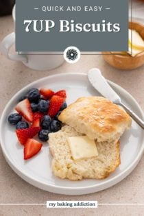 Buttered 7up biscuit next to fresh berries on a white plate. Text overlay includes recipe name.