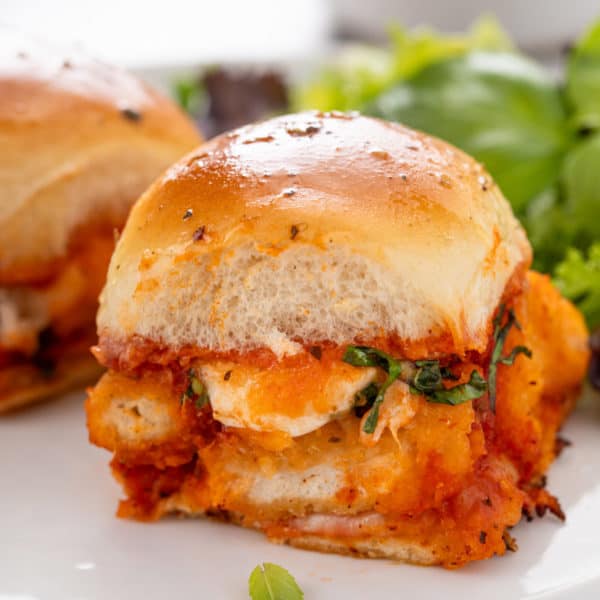 Close up of a chicken parmesan slider on a plate.