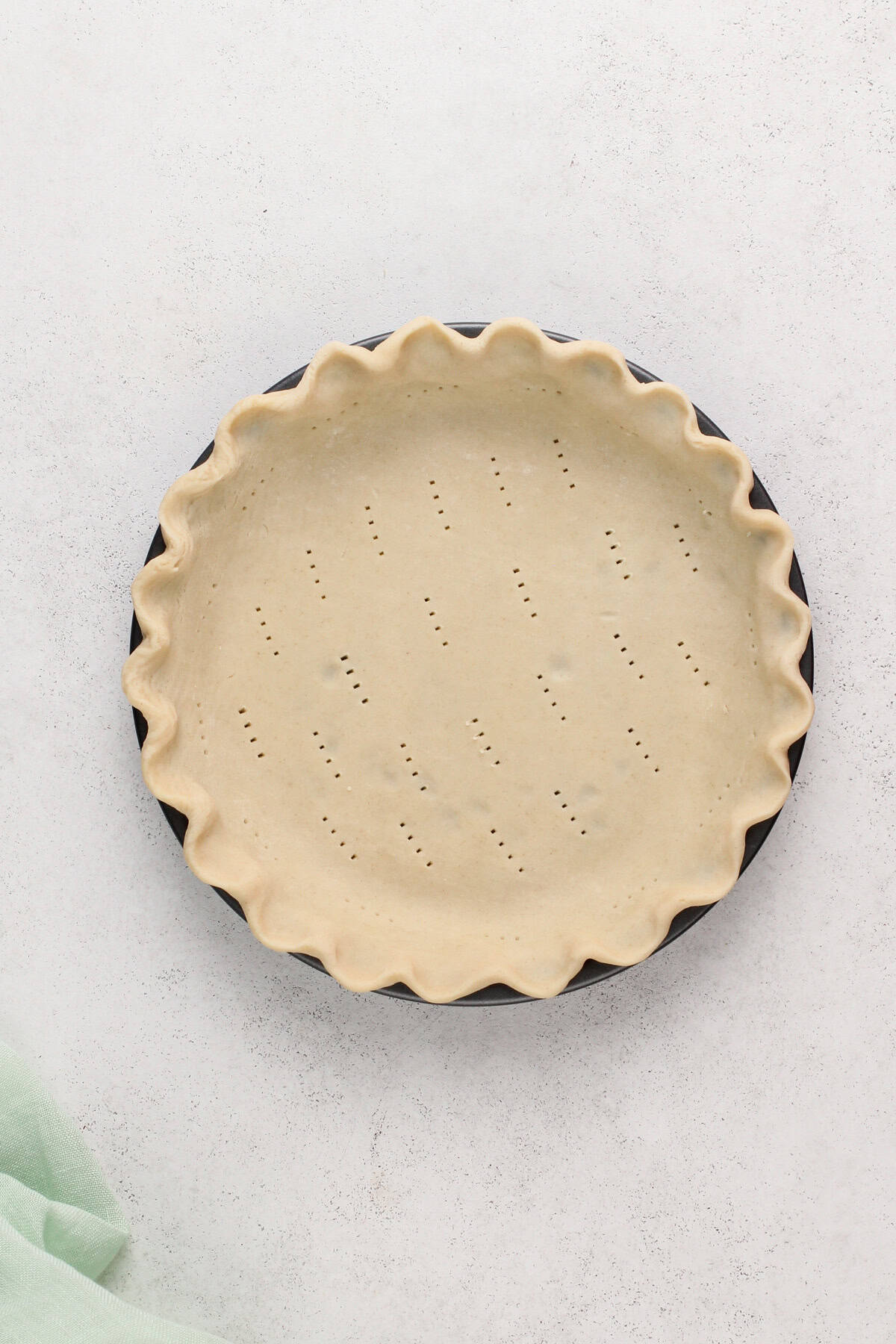Pie crust crimped in a pie plate and poked with a fork for blind baking.
