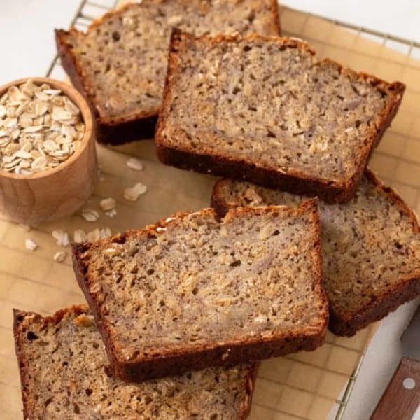 Several slices of oatmeal banana bread arranged on a wire cooling rack.