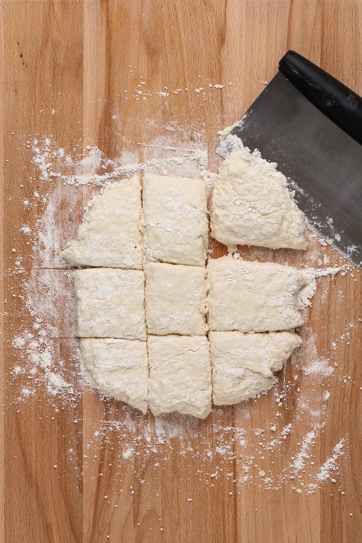 7up biscuit dough cut into 9 biscuits on a floured board.