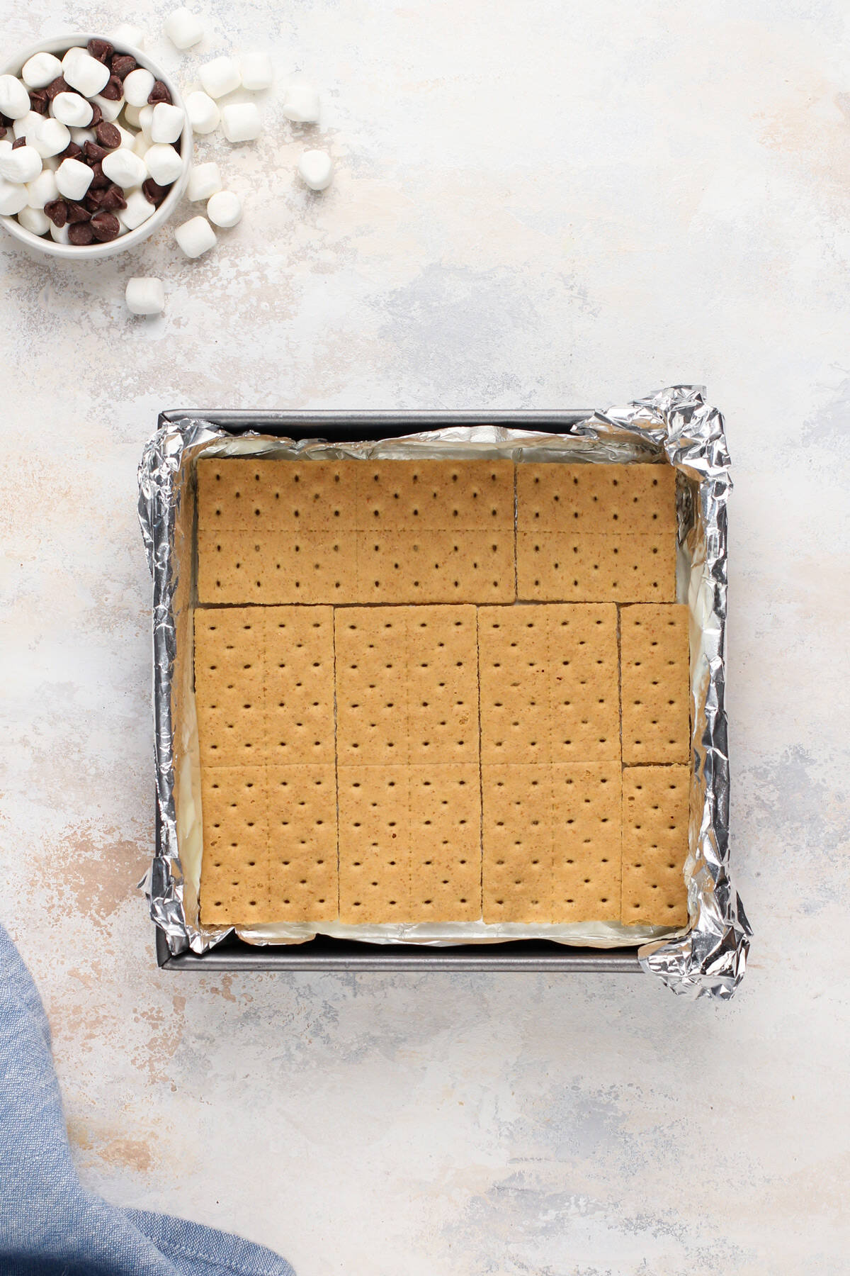Graham crackers fit into the bottom of a foil-lined baking pan.