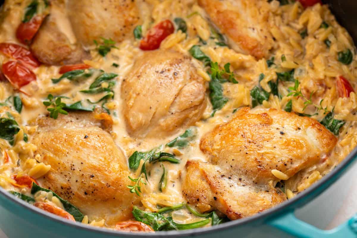 Close up of one-pot lemon chicken and orzo in a dutch oven.