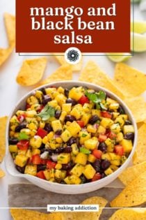 Bowl of mango and black bean salsa surrounded by tortilla chips. Text overlay includes recipe name.