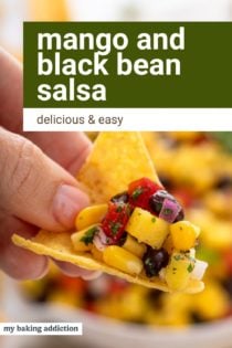 Mango and black bean salsa on a tortilla chip. Text overlay includes recipe name.