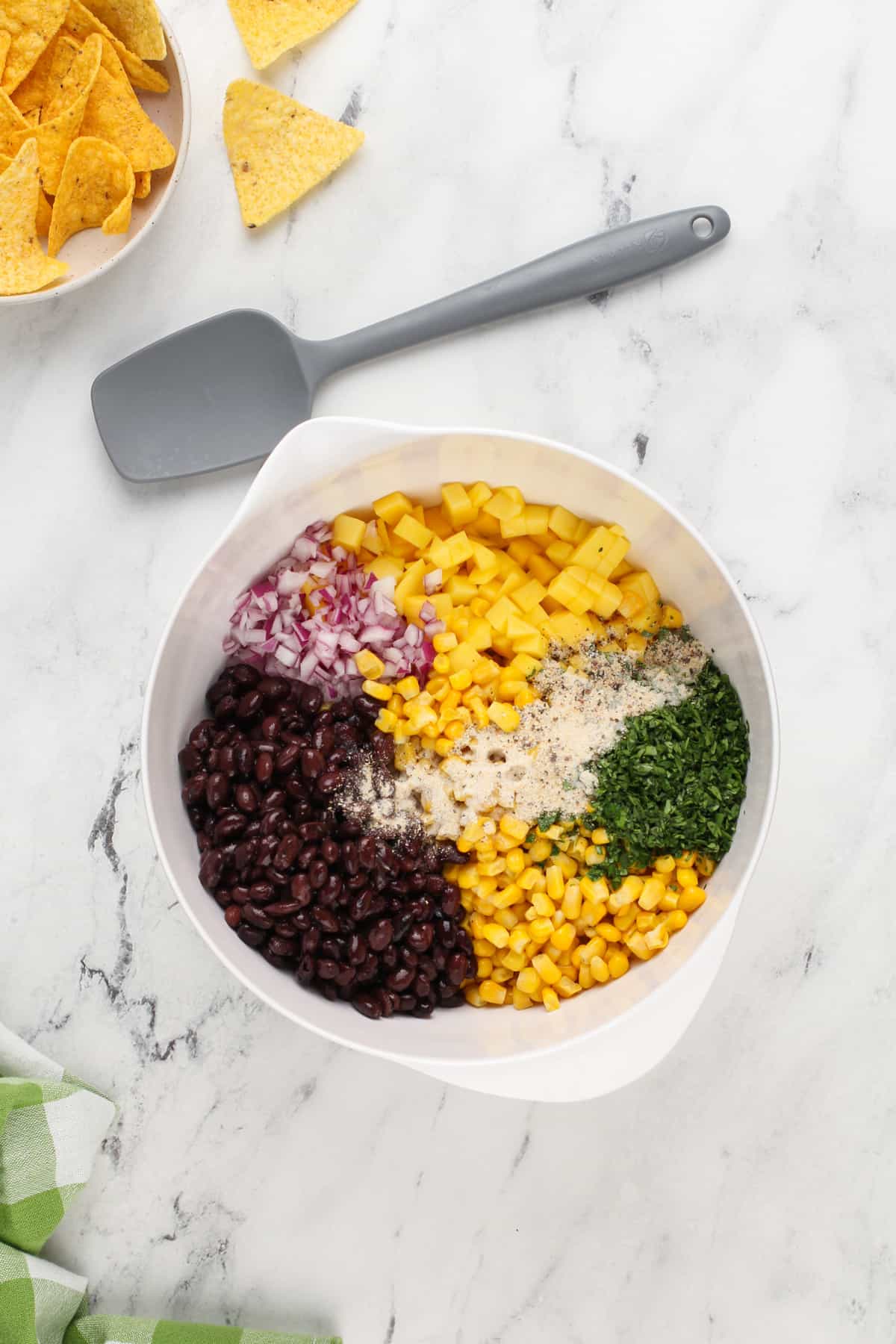 Ingredients for mango salsa in a white bowl.