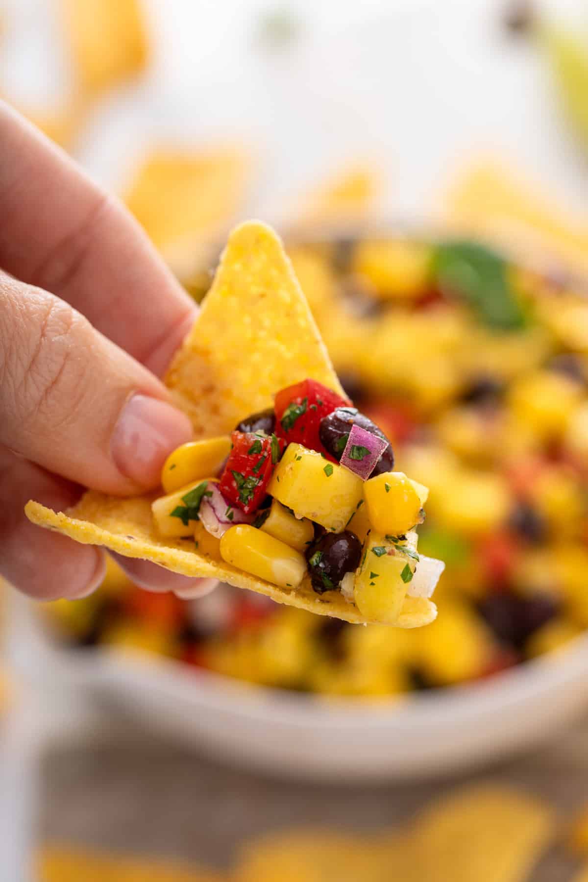 Mango and black bean salsa on a tortilla chip.