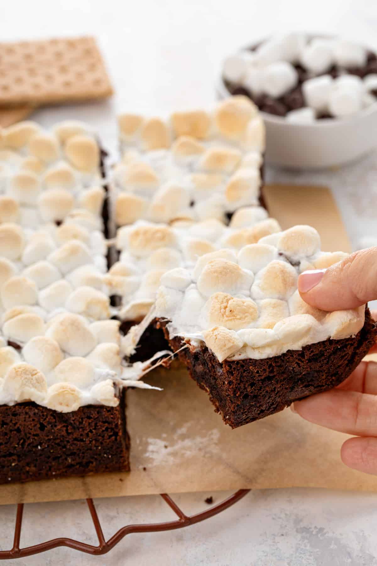 Hand picking an easy s'mores brownie from other sliced brownies.