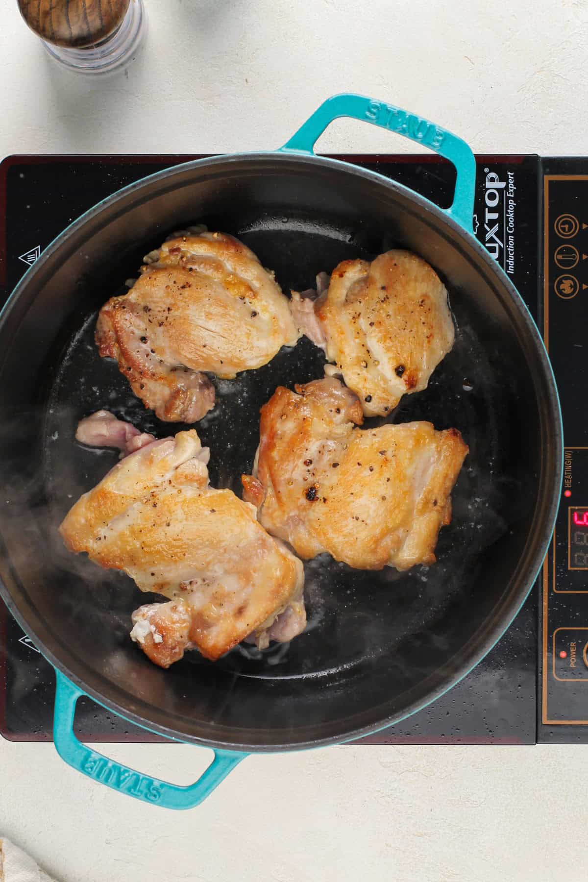 Seared chicken thighs in a dutch oven.