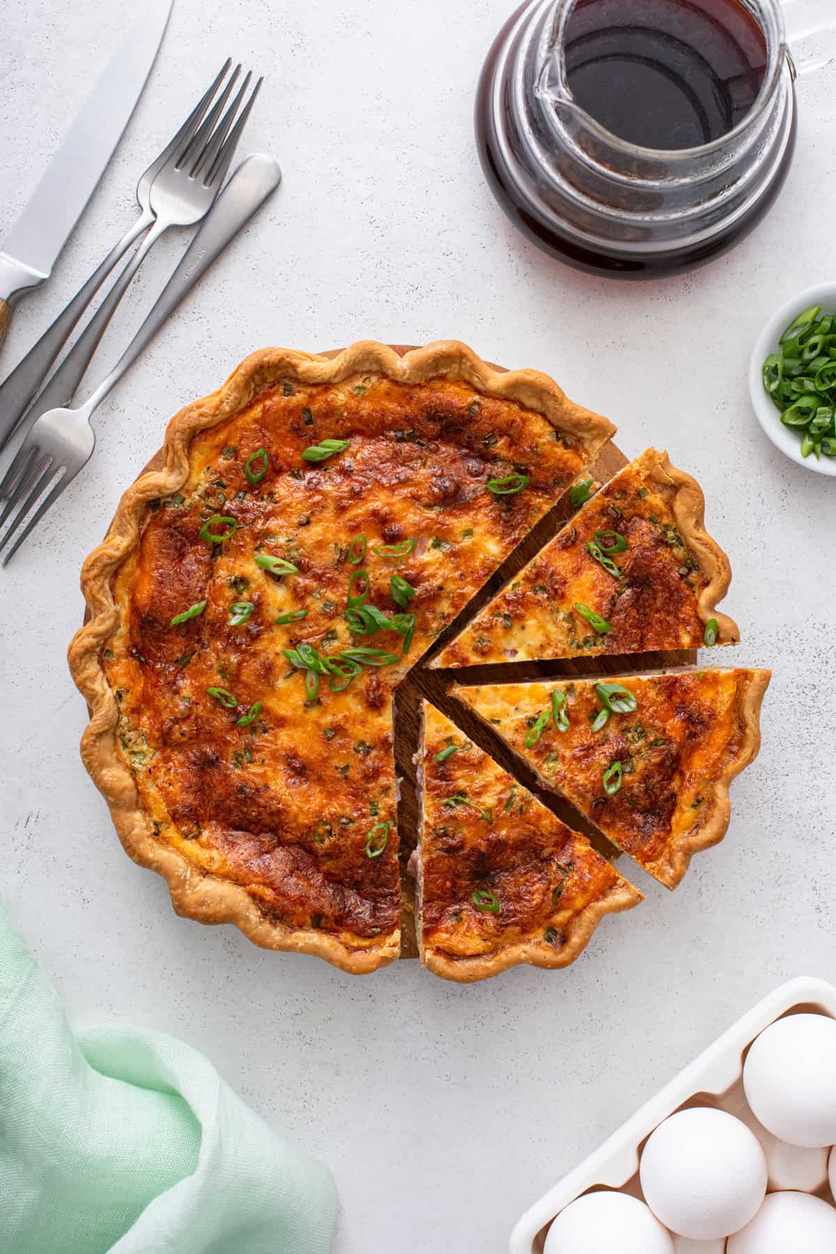 Overhead view of a sliced ham and cheese quiche.