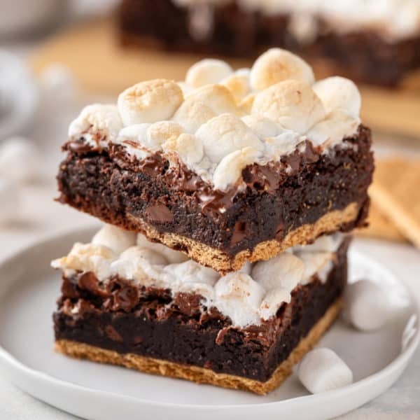 Stacked easy s'mores brownies on a white plate.