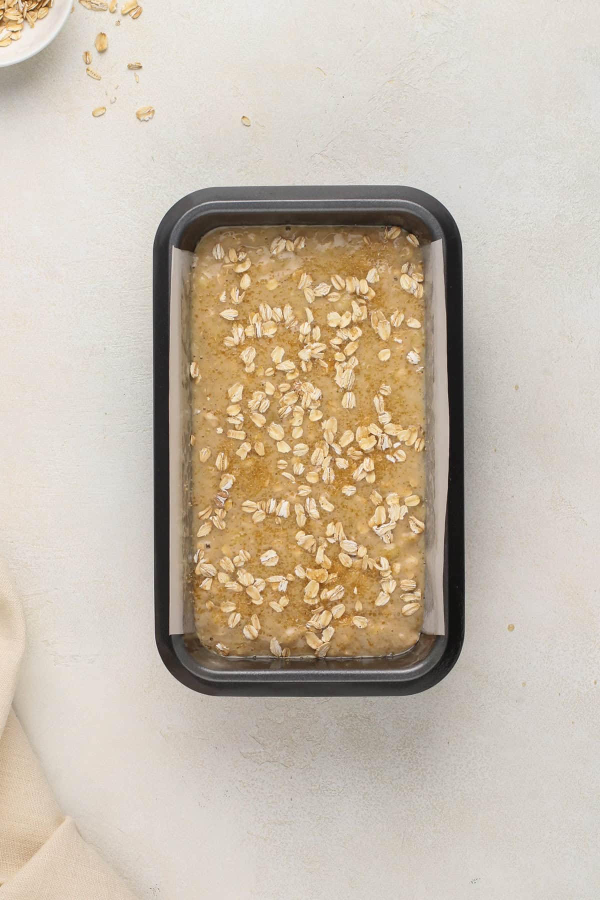 Oatmeal banana bread batter in a loaf pan, ready to go in the oven.