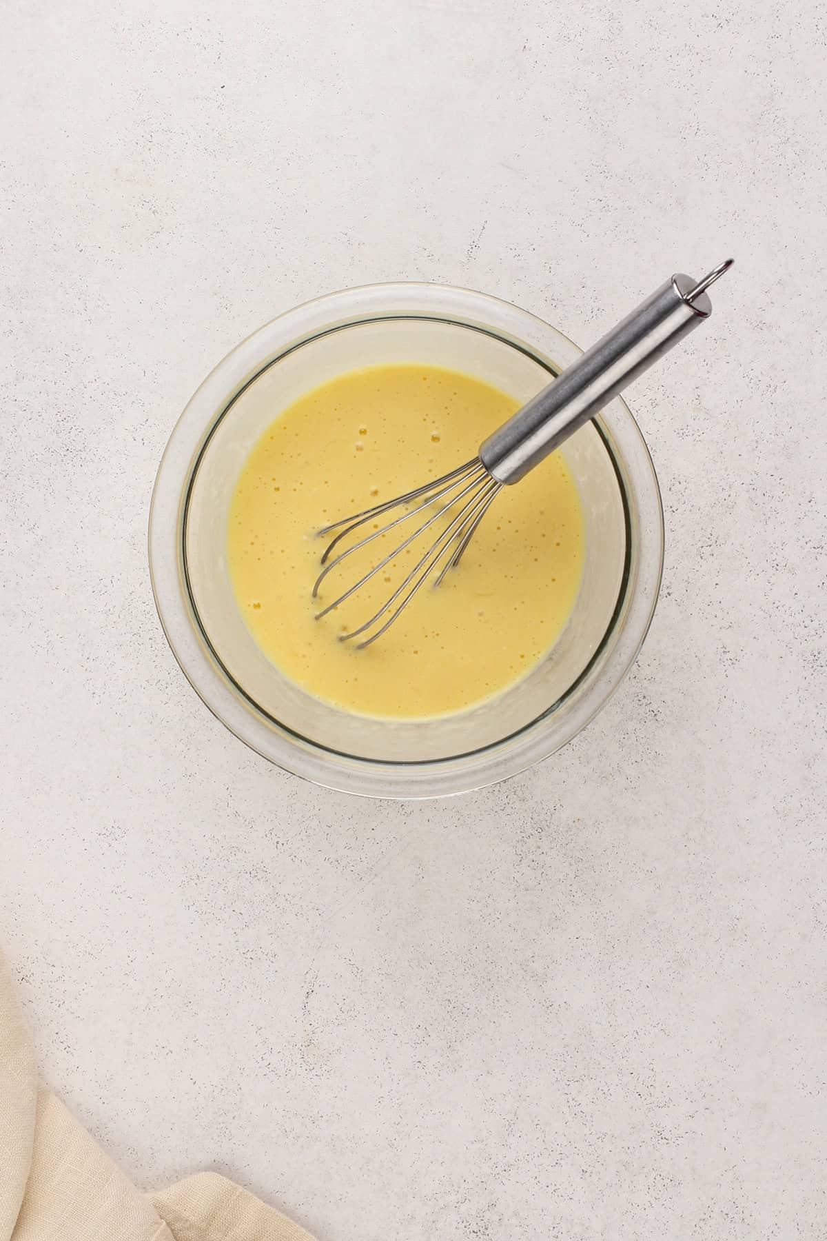 Wet ingredients for texas sheet cake whisked together in a glass bowl.