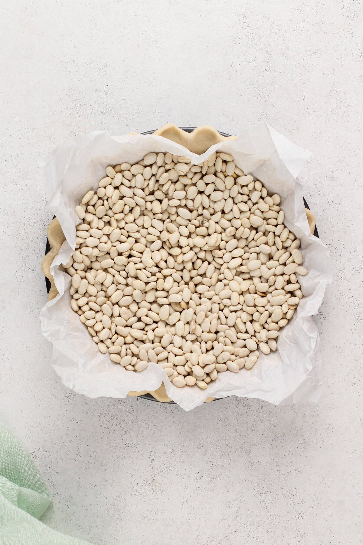 Dried beans in a parchment-lined pie crust.