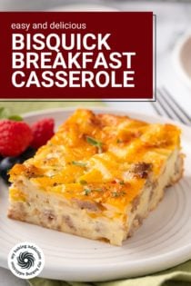 Close up of a slice of bisquick breakfast casserole next to fresh berries on a white plate. Text overlay includes recipe name.