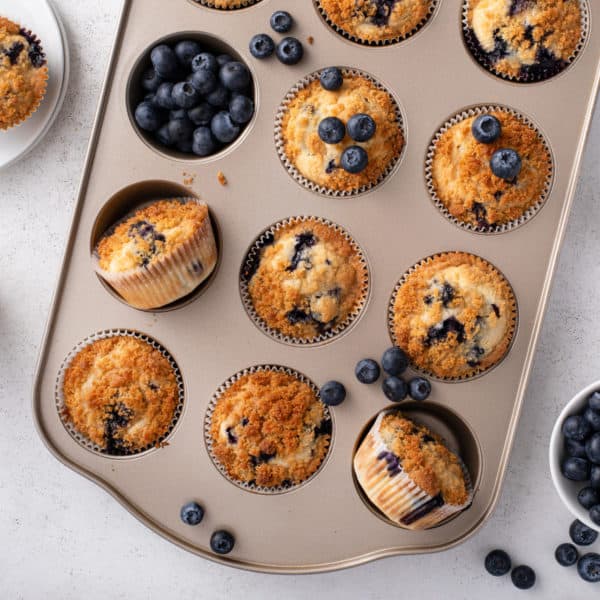Overhead view of cooled blueberry muffins in a muffin tin.
