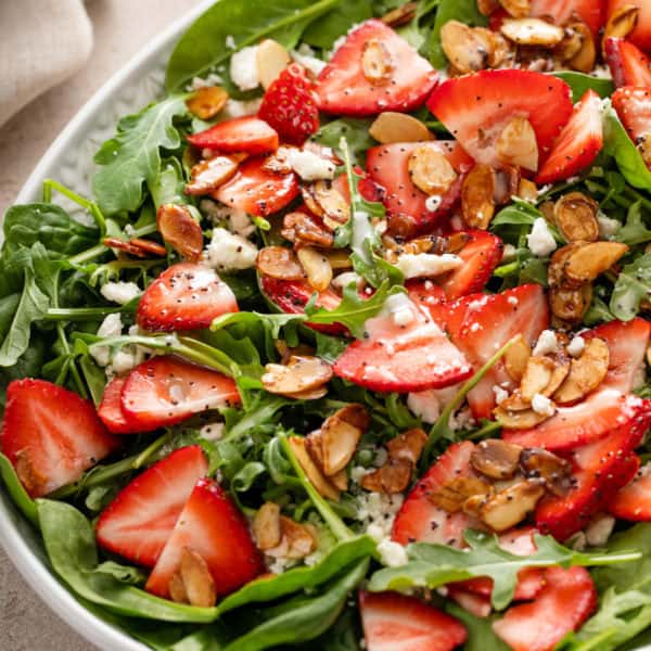 Close up of dressed strawberry salad in a serving bowl.