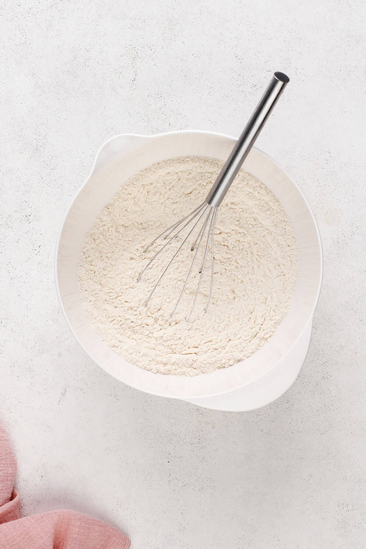 Dry ingredients for easy sugar cookies whisked together in a white bowl.