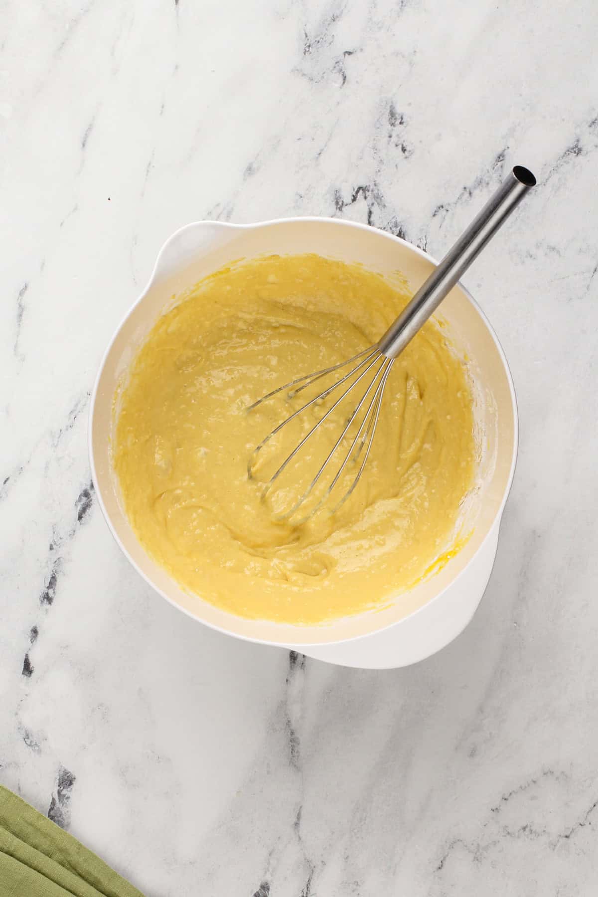 Eggs and bisquick mix whisked together in a white bowl.