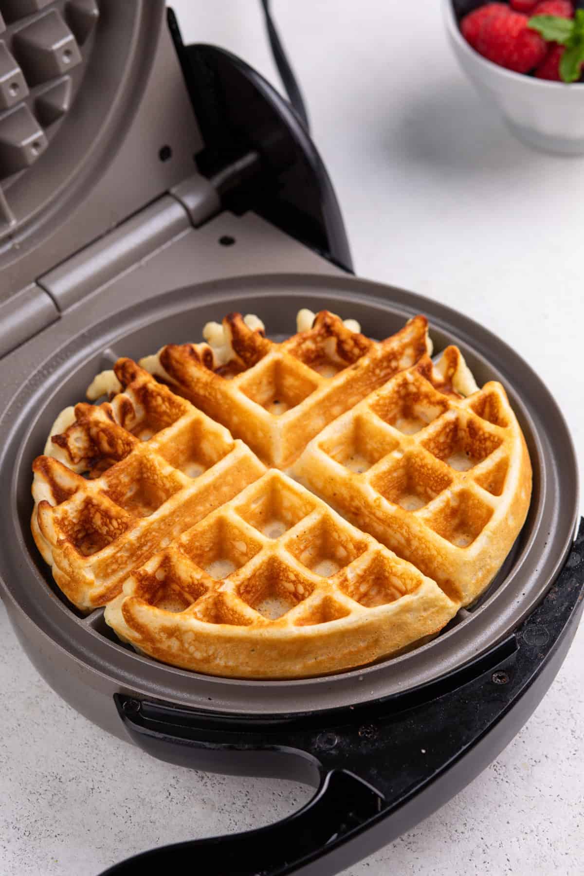 Cooked waffle in an open waffle iron.