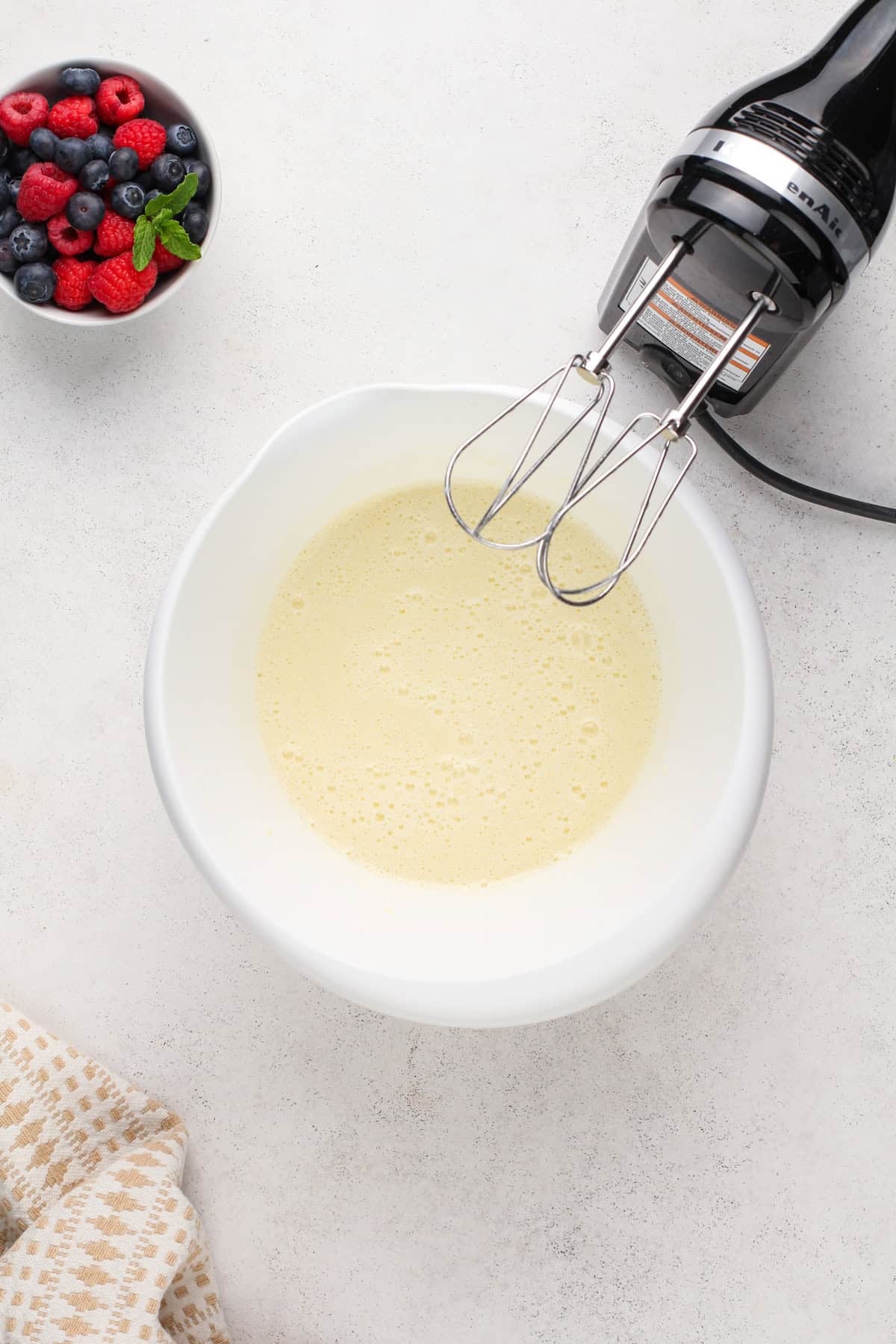 Wet ingredients for homemade waffles mixed together in a white bowl.