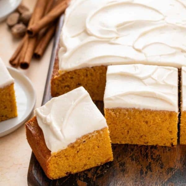 Slices of pumpkin sheet cake on a serving board.