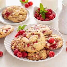White plate filled with white chocolate raspberry cookies.
