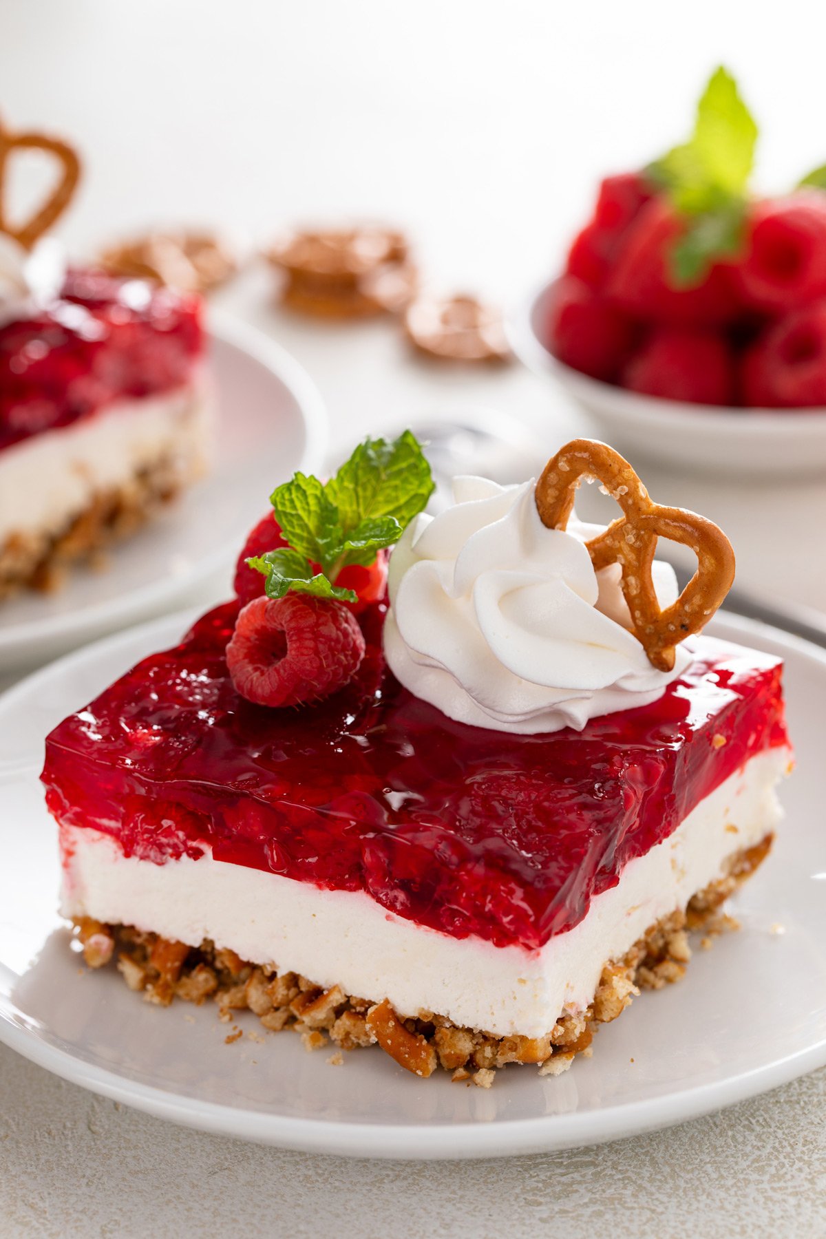 Close up of raspberry pretzel salad on a white baking dish.