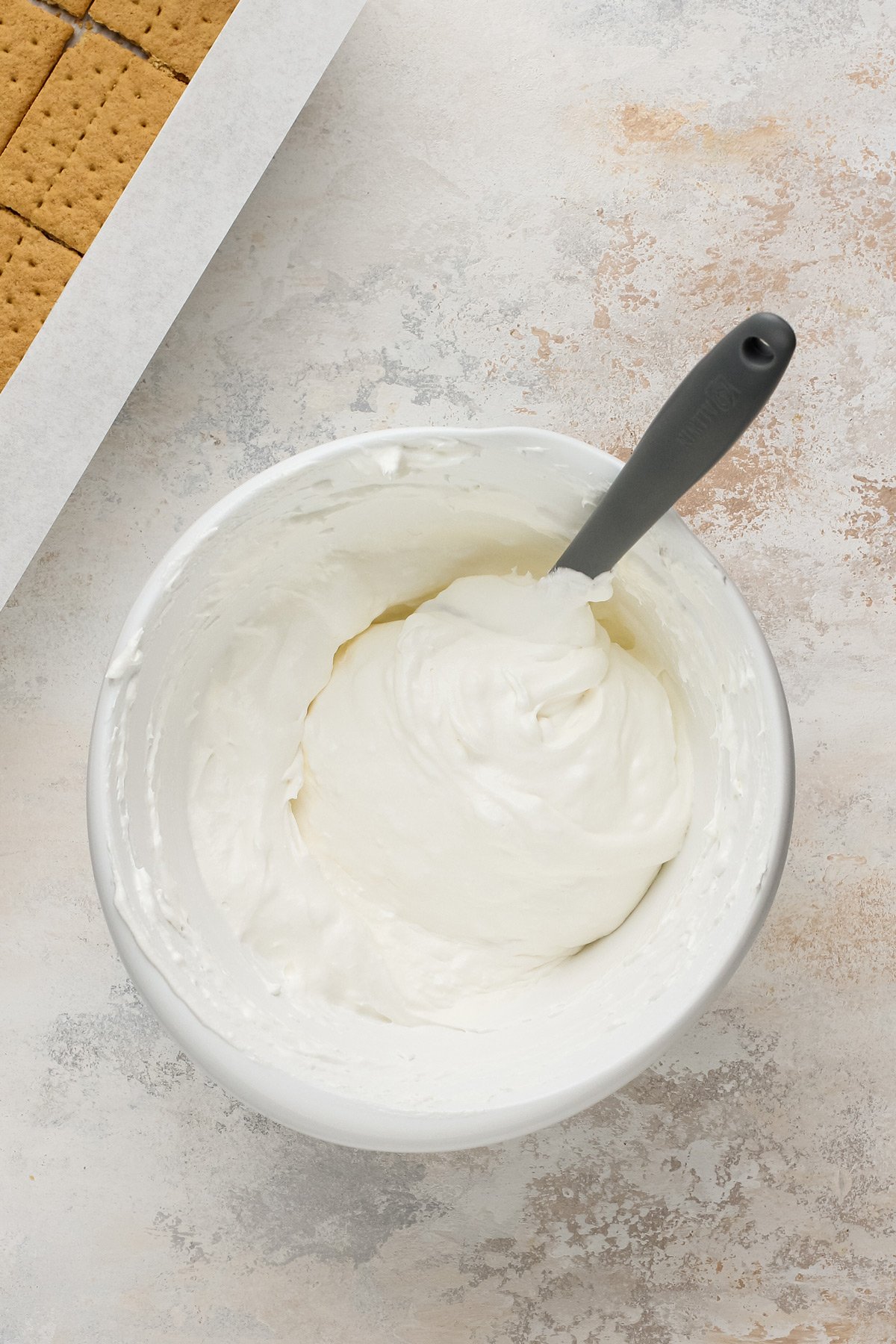 Marshmallow filling for frozen s'mores mixed in a white bowl.