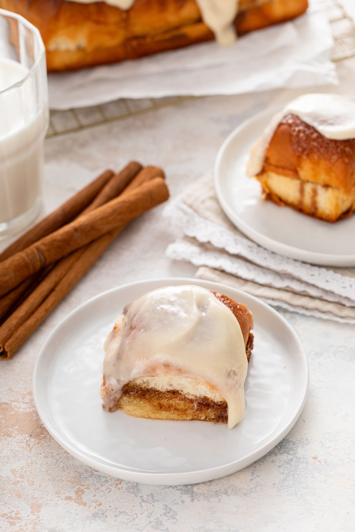 Two white plates holding hawaiian roll cinnamon rolls.