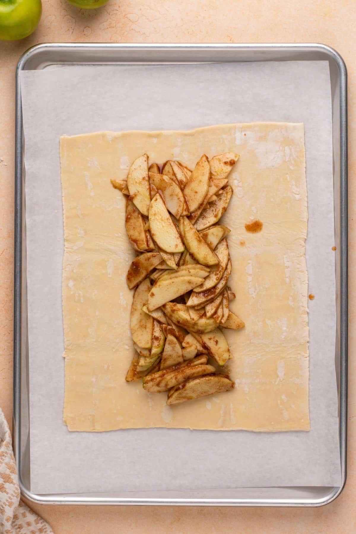 Apple filling arranged in the middle of a sheet of puff pastry.