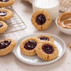 Plate of peanut butter and jelly cookies and a glass of milk.