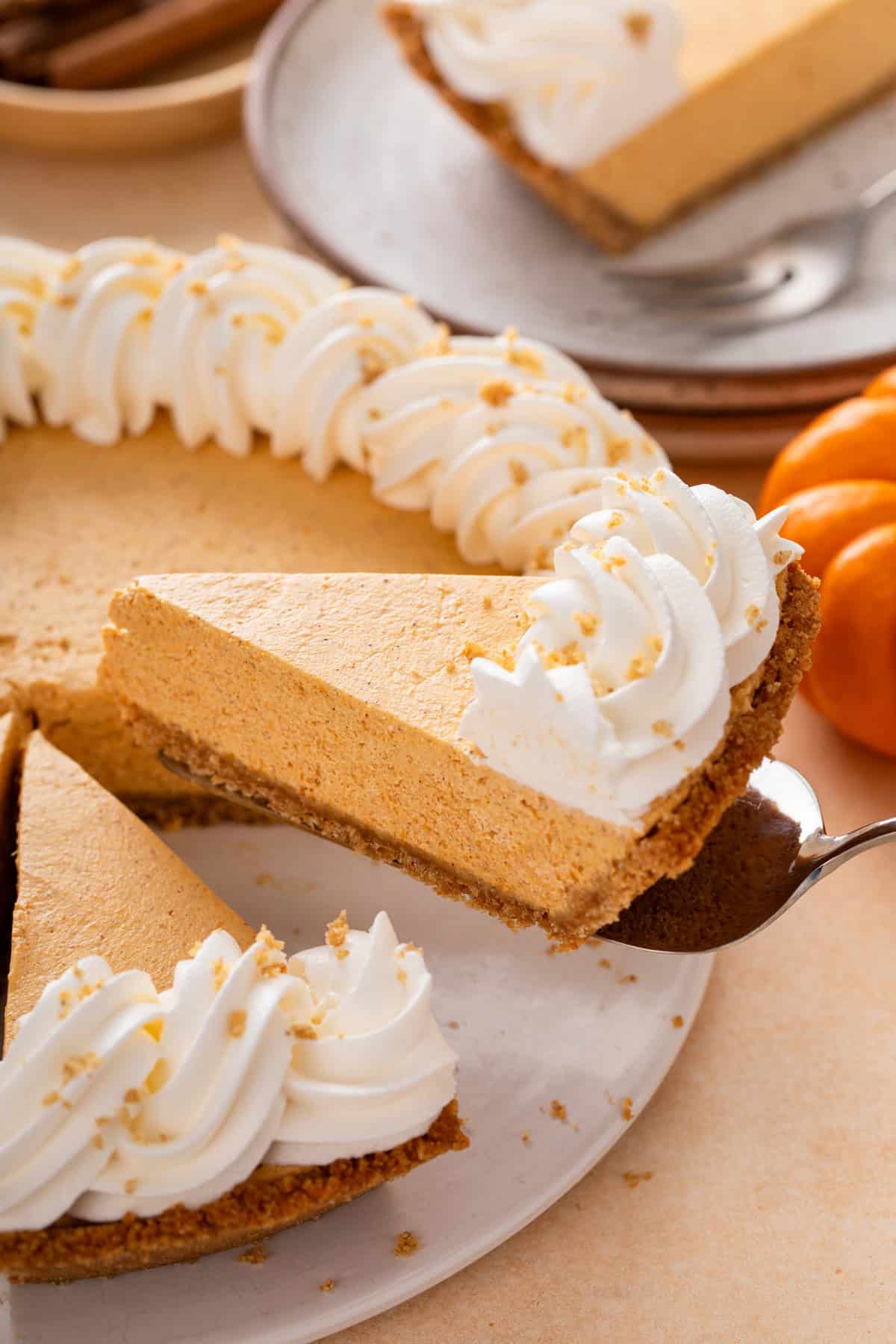 Slice of no-bake pumpkin cheesecake pie being lifted by a pie server.